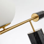 Shot along the diagonal arm, the Clérachic lamp's marble finial is sharp while its glass globe blurs softly behind it.