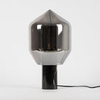 The same pointed smoked-glass Clérachic lamp on its black veined marble base, photographed straight on.