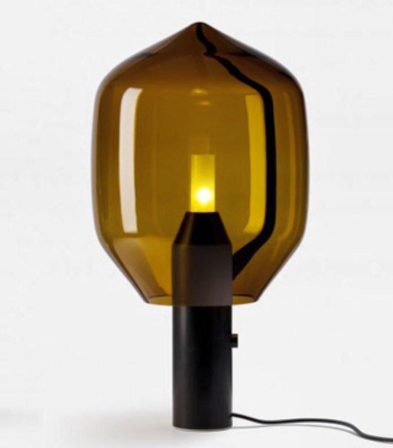 Clérachic's amber-glass lamp on its black base, lit from a slightly different angle against a plain white backdrop.