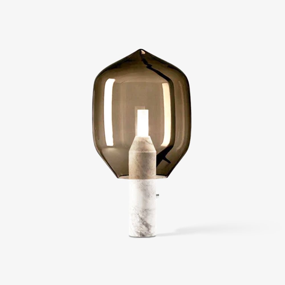 A smoked-glass Clérachic table lamp on a white marble base, standing alone with a soft shadow on a white backdrop.