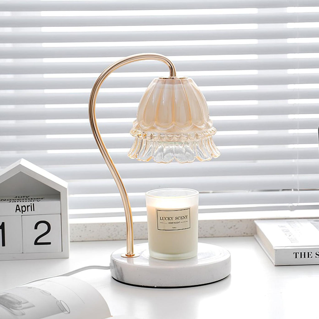 Next to a wooden desk calendar and a stack of books, this Clérachic candle warmer lamp's shade hangs over its candle jar.