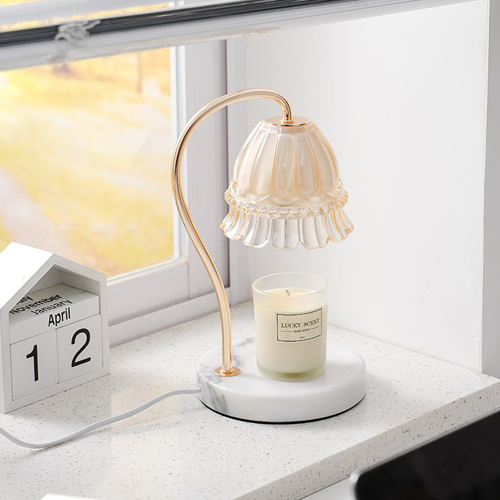 In soft window light on a terrazzo-look counter, this Clérachic candle warmer lamp stands beside a wooden desk calendar.