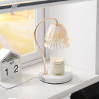 In soft window light on a terrazzo-look counter, this Clérachic candle warmer lamp stands beside a wooden desk calendar.
