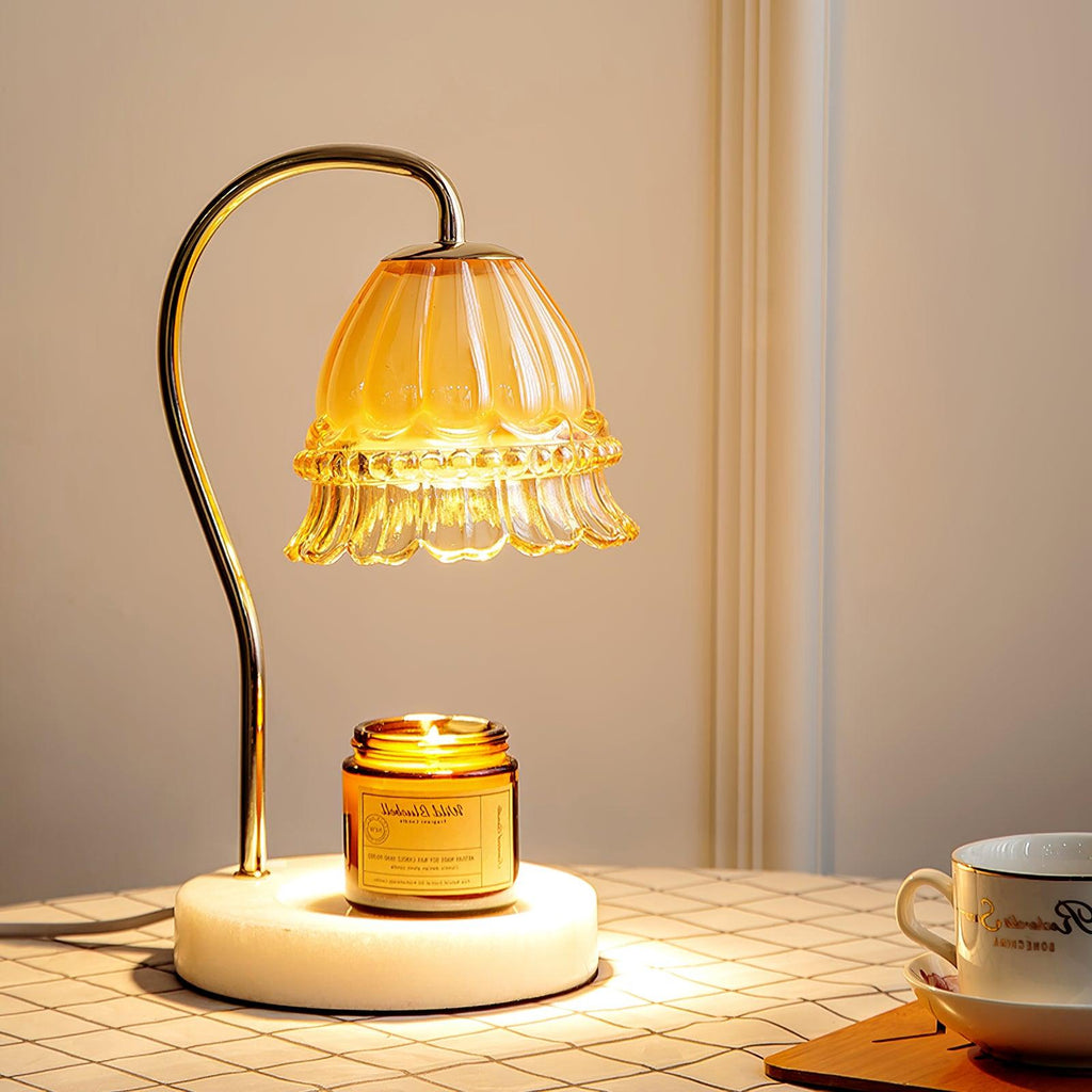 Glowing warmly on a checked tablecloth, this Clérachic candle warmer lamp lights its amber candle jar beside a teacup.