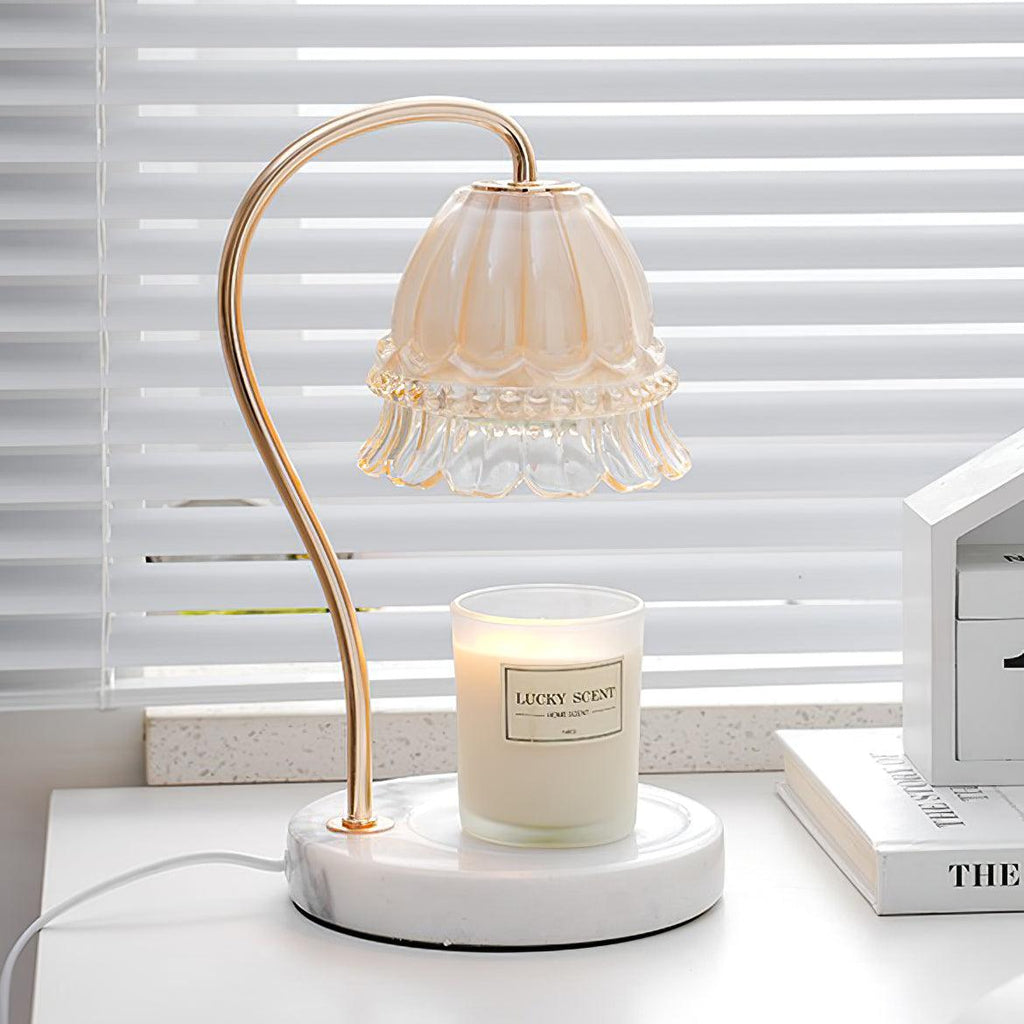 On a marble-topped bedside table near venetian blinds, this Clérachic candle warmer lamp sits beside a small stack of books.