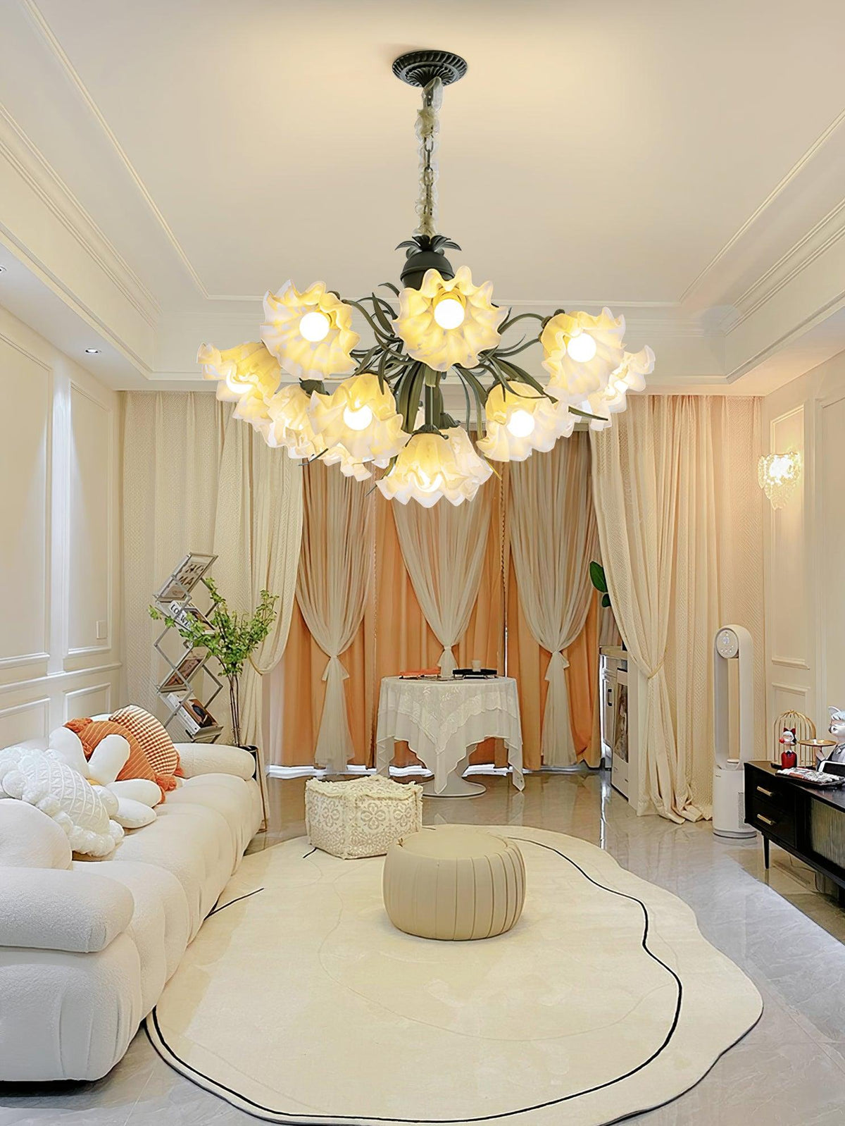 Against a draped orange backdrop in a living room, this Clérachic chandelier glows above a round pouf and rug.