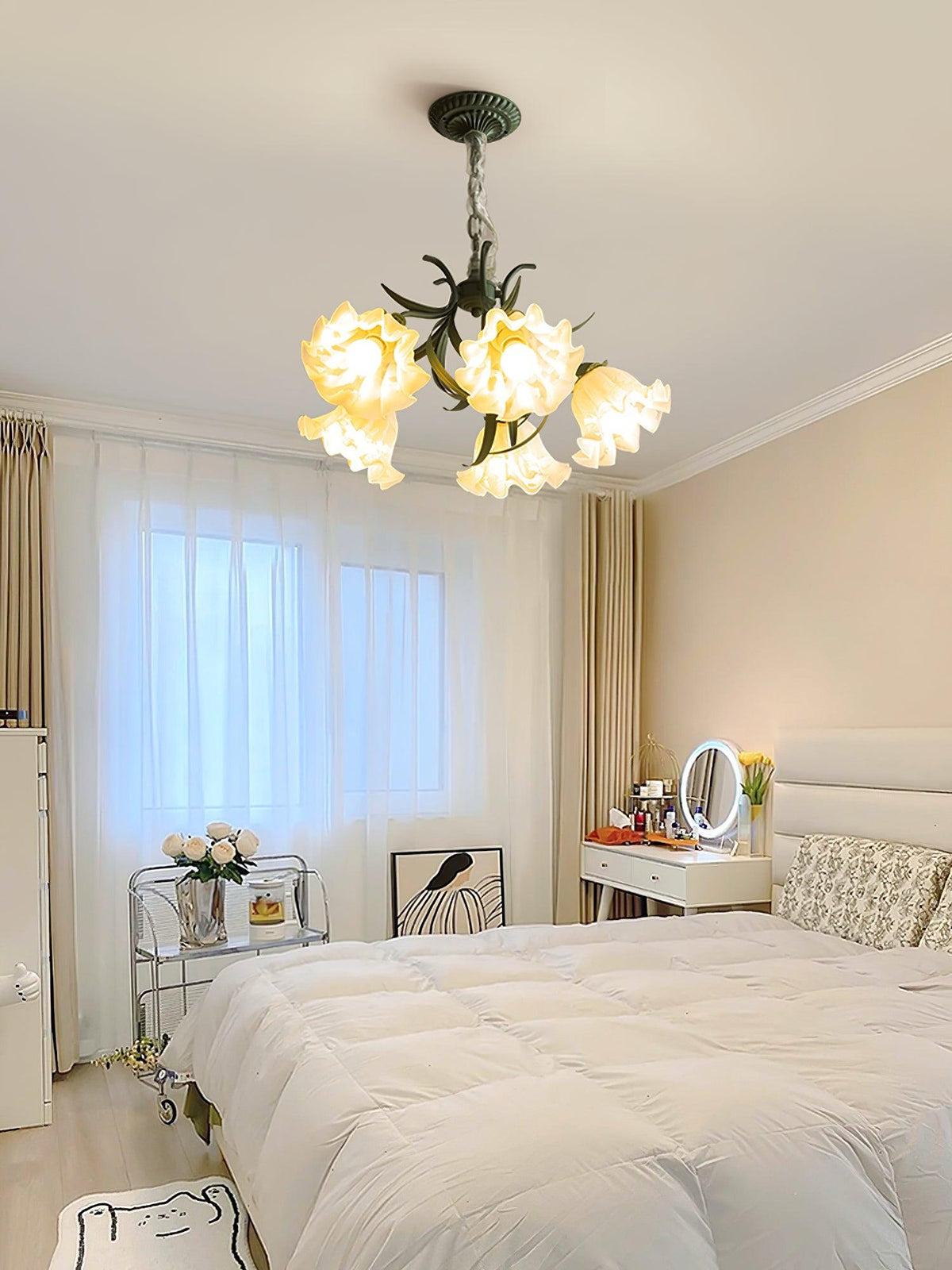 Above a cream bed and vanity mirror, this Clérachic chandelier lights a soft bedroom.