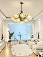 Through an arched doorway in a living room with a round rug, this Clérachic chandelier lights the space.