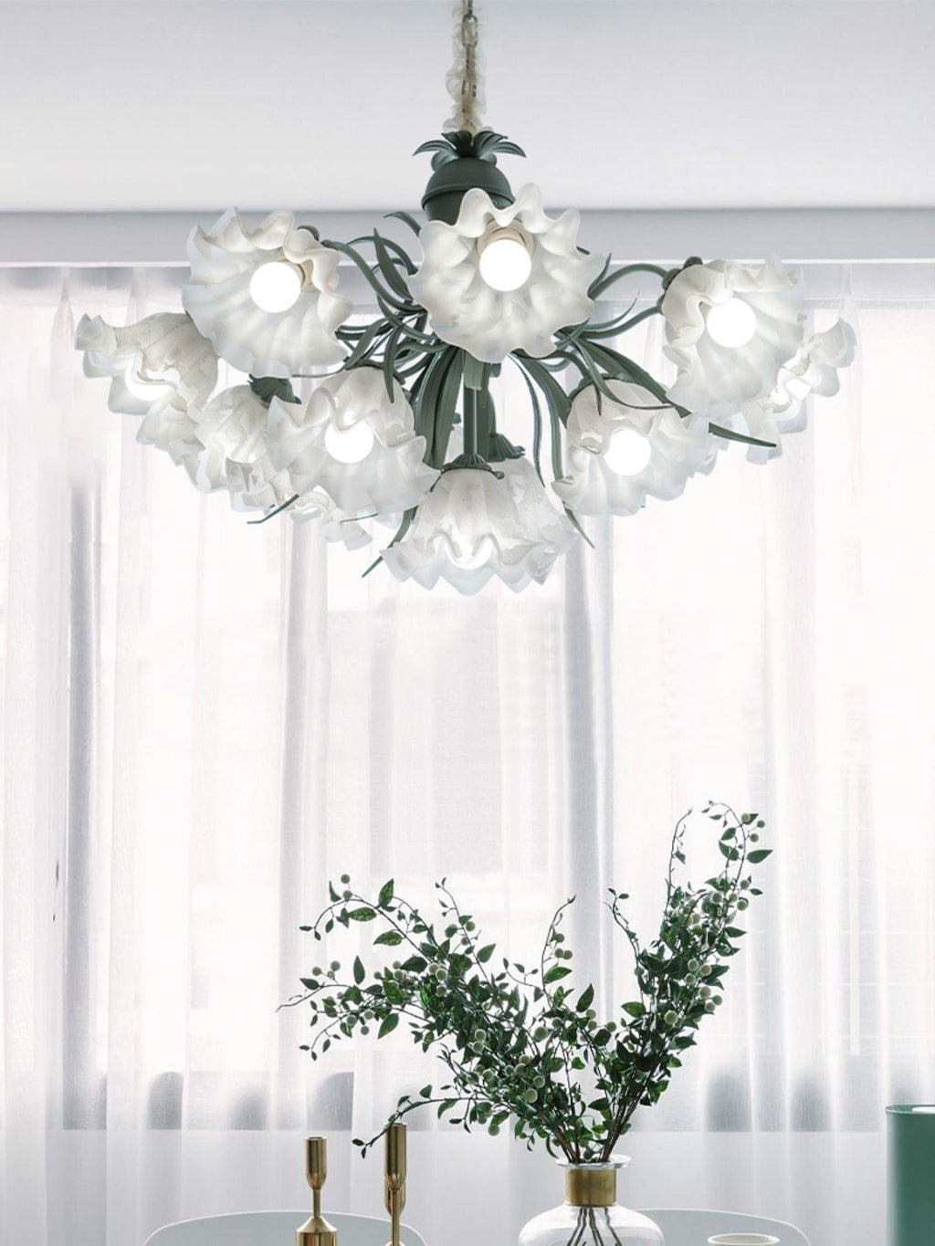 Framed by sheer white curtains, this Clérachic chandelier's shades catch the light, unlit, beside a vase of greenery.