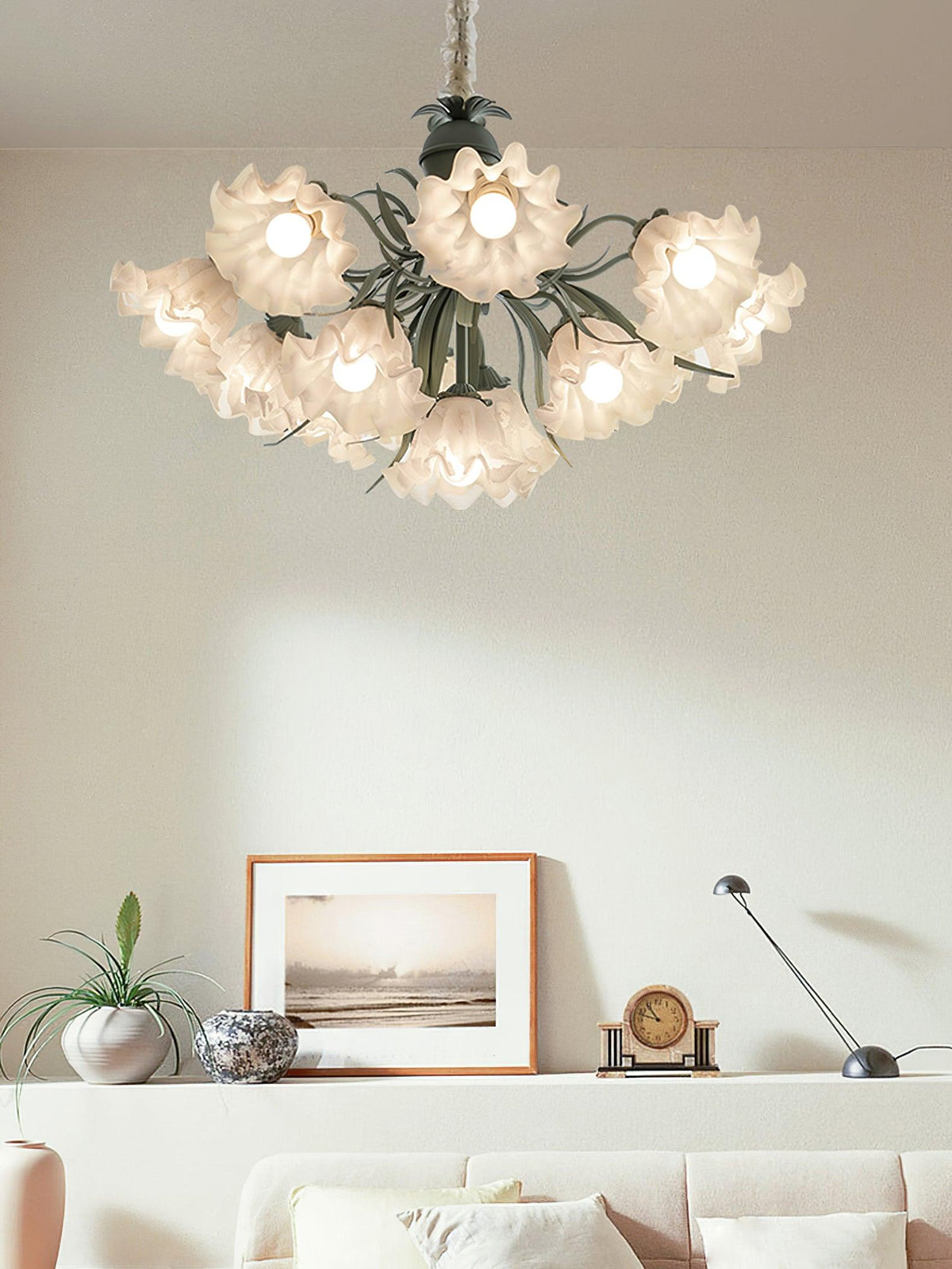 Over a mantel with a framed print and desk lamp, this Clérachic chandelier lights a bright room.