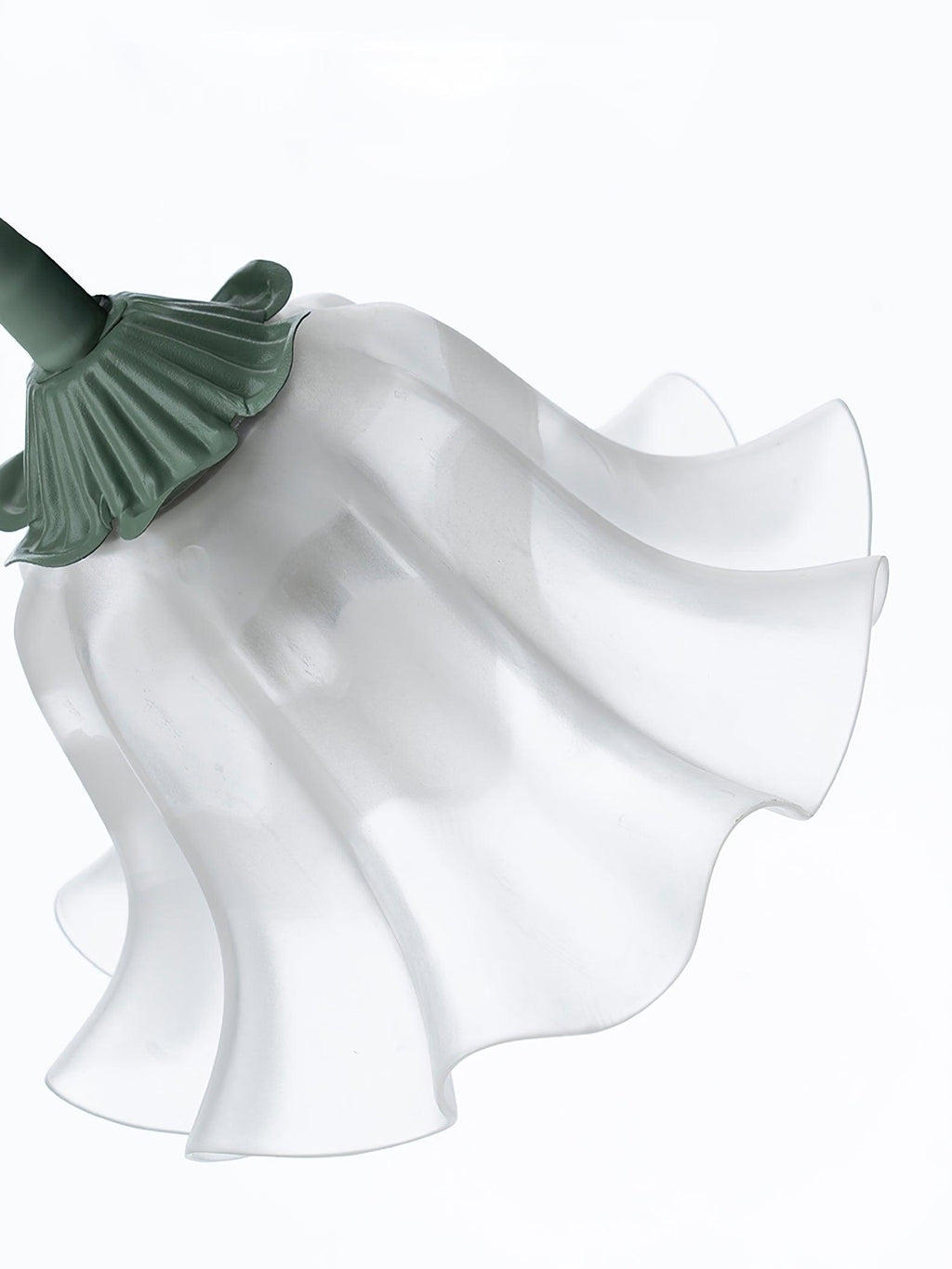 Close view of an unlit shade on this Clérachic chandelier, showing its fluted white petals and green fitting.