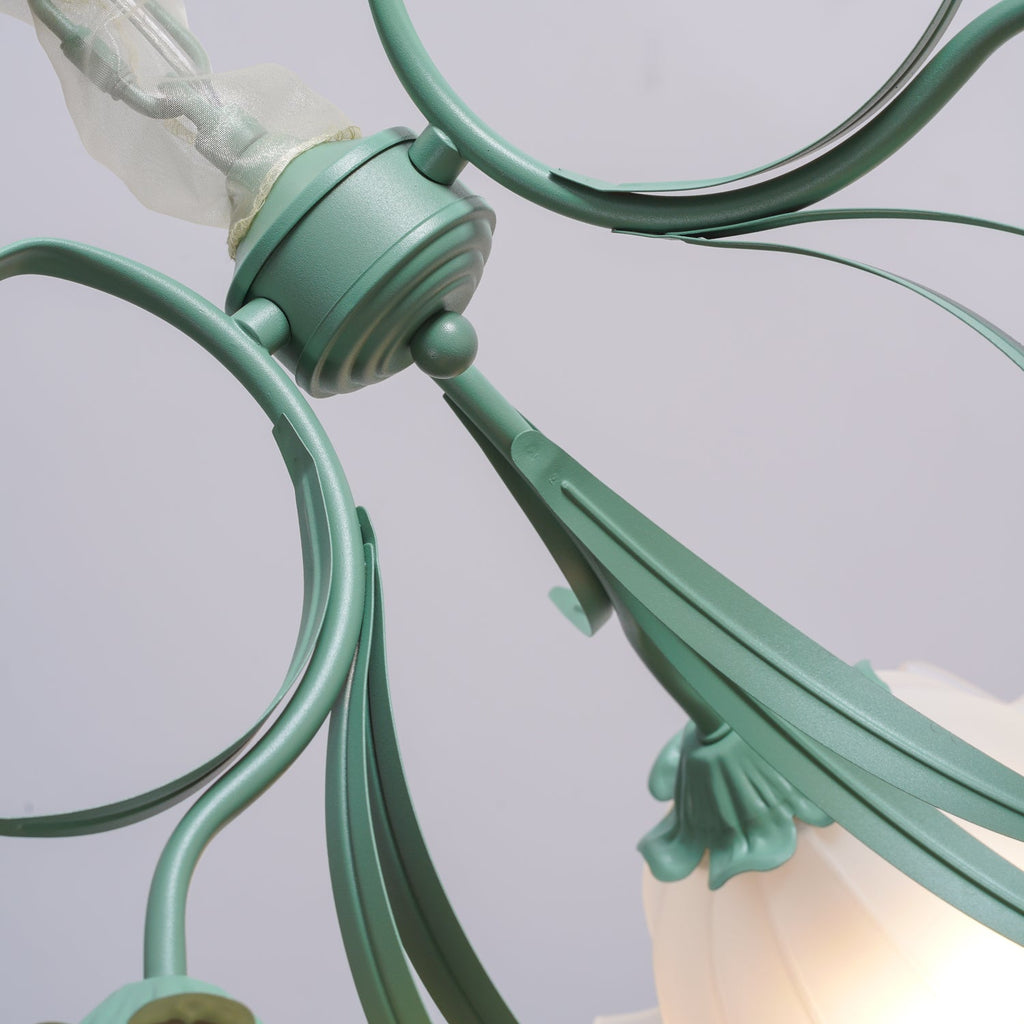 Close view of the sage-green metal arms on this Clérachic chandelier, unlit, showing the fluted stem detail.