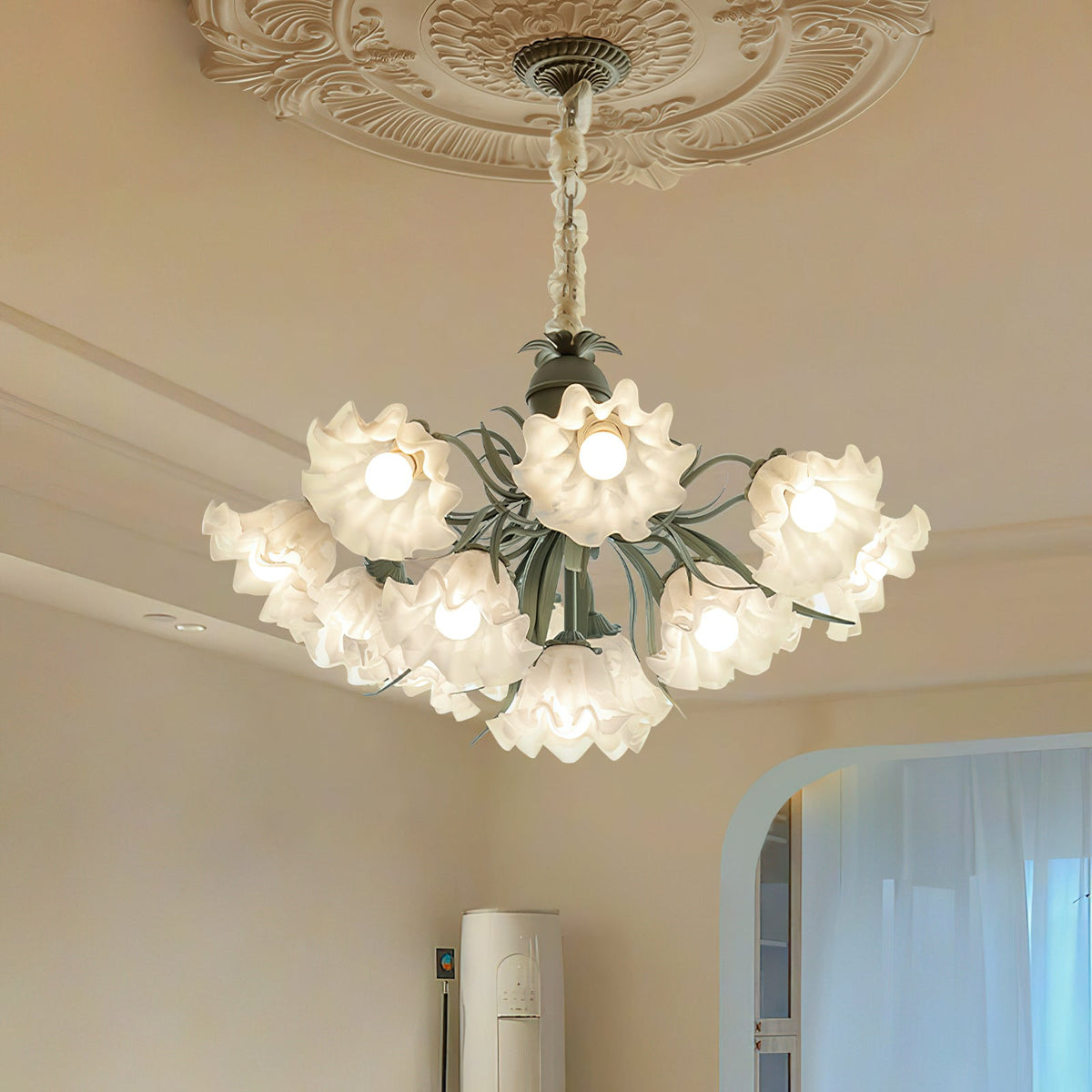 Seen from below against a carved ceiling medallion, this Clérachic chandelier's shades glow warm gold.