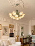 Above a gallery wall of framed prints, this Clérachic chandelier lights a neutral living room.