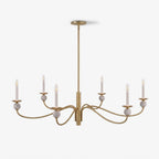 On a plain backdrop, the wave arms and stone ball accents of this Clérachic chandelier show a brushed brass finish, unlit and front-on.