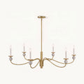 Angled on a plain backdrop, this Clérachic chandelier's brushed brass wave arms and stone ball accents catch the light, unlit.