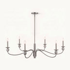 On a plain backdrop, this Clérachic chandelier shows its brushed nickel wave arms and stone ball accents, unlit and centred.