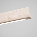 An angled close view of this Clérachic pendant shows the travertine's veining and its glowing LED edge.
