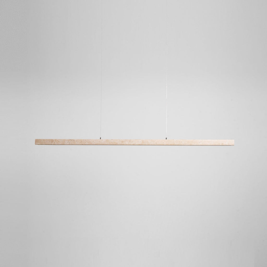 Product-only view of this Clérachic pendant's travertine bar, shown unlit and level against a plain grey backdrop.
