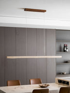 A wider view shows this Clérachic pendant's travertine bar glowing above a marble table with open shelving in the background.