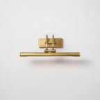 Brushed brass and bronze vanity light glowing soft warm light