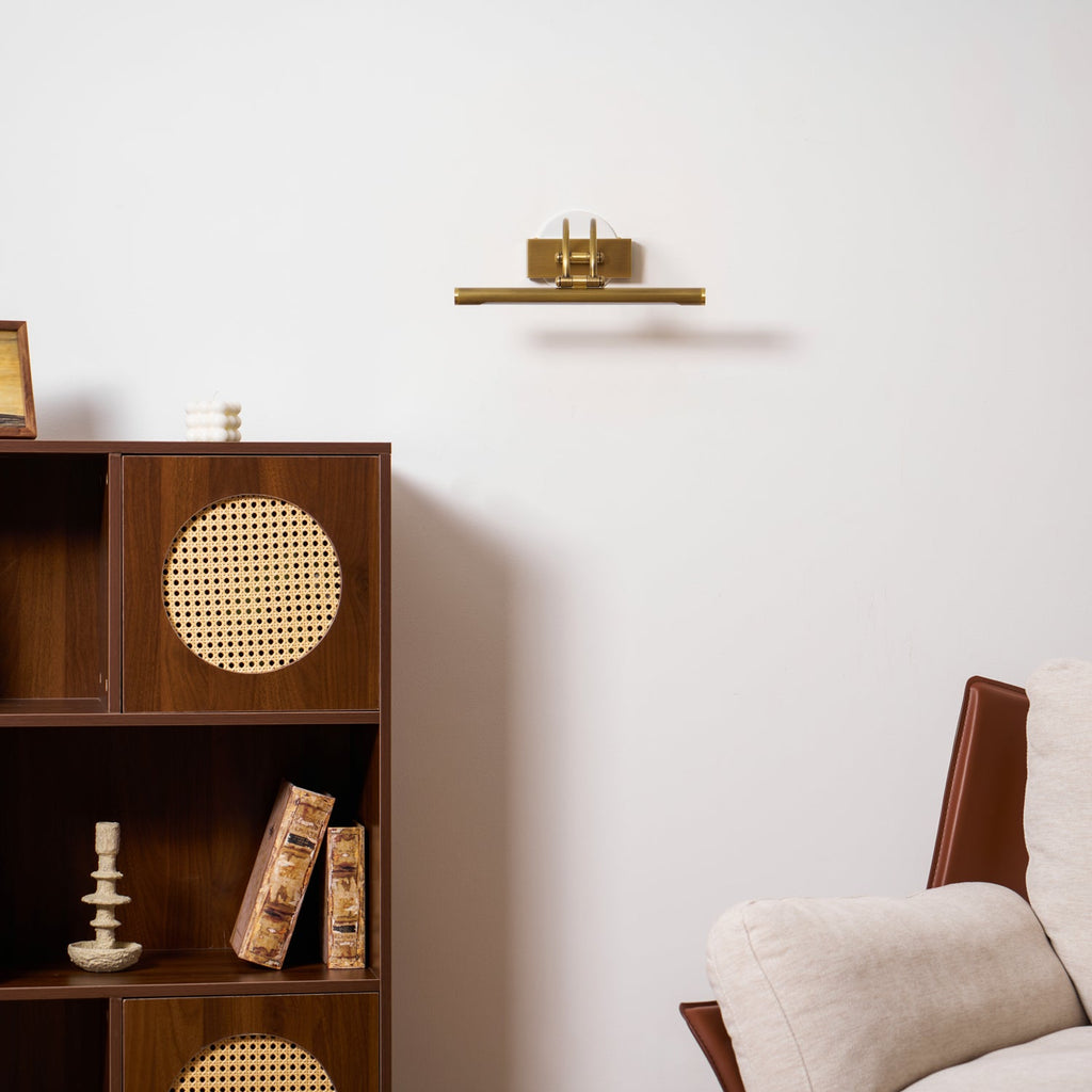 Two-tone bronze and brass vanity light against a plain wall