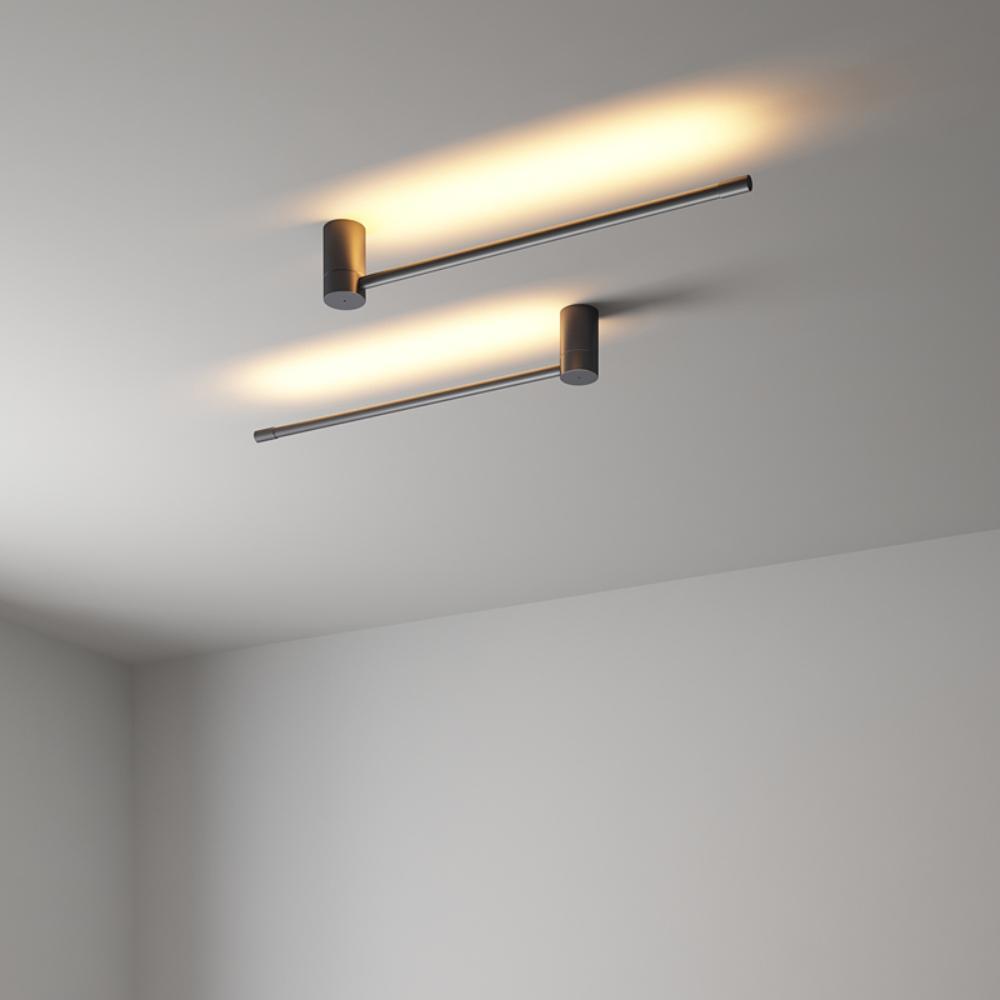Slim LED tube wall light glowing warm beside a quiet niche