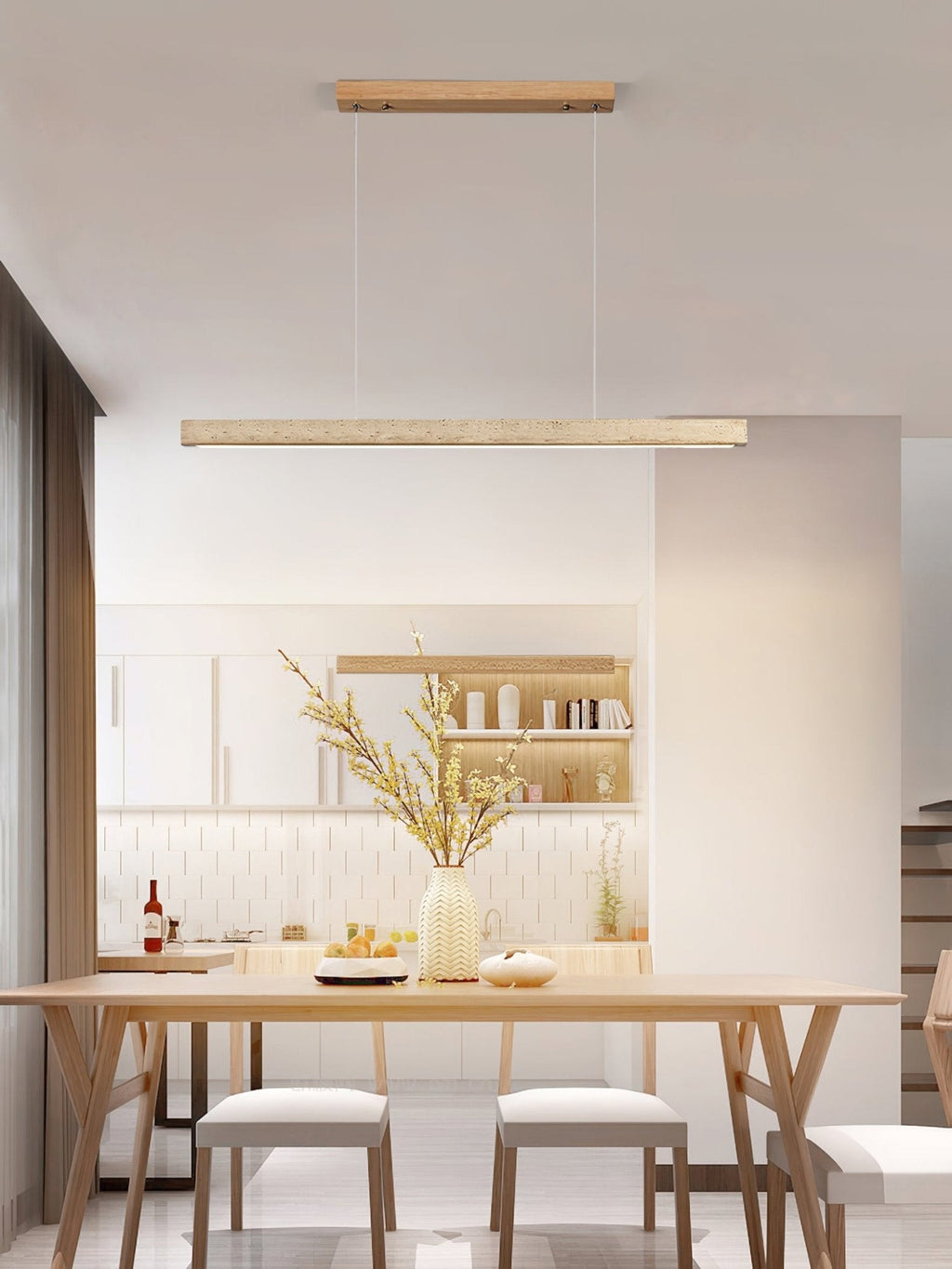 This Clérachic pendant hangs above a wood dining table set with dried flowers, its travertine bar glowing warm beneath open shelving.