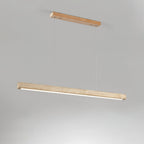 This Clérachic pendant hangs from a pale wood canopy, its travertine bar glowing warm along the underside on a grey backdrop.