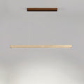 This Clérachic pendant's dark walnut canopy and travertine bar glow warm along the underside, shown on a grey backdrop.
