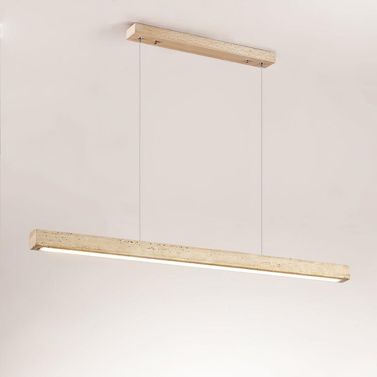 Shown against a warm beige backdrop, this Clérachic pendant's travertine bar glows along its underside.