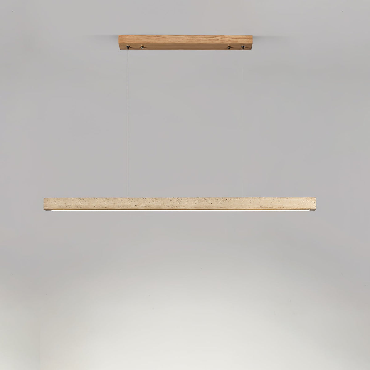 This Clérachic pendant's pale wood canopy and travertine bar glow warm along the underside, shown on a grey backdrop.