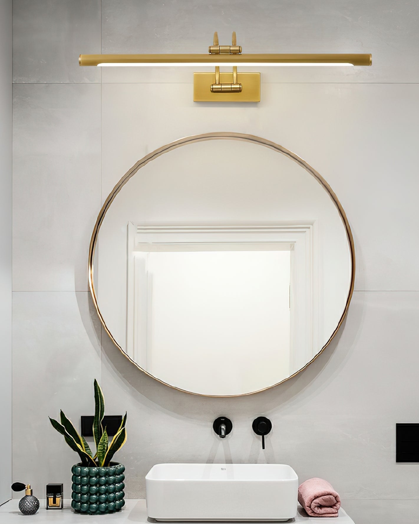 Brushed brass accented vanity bar washing light across a reflection
