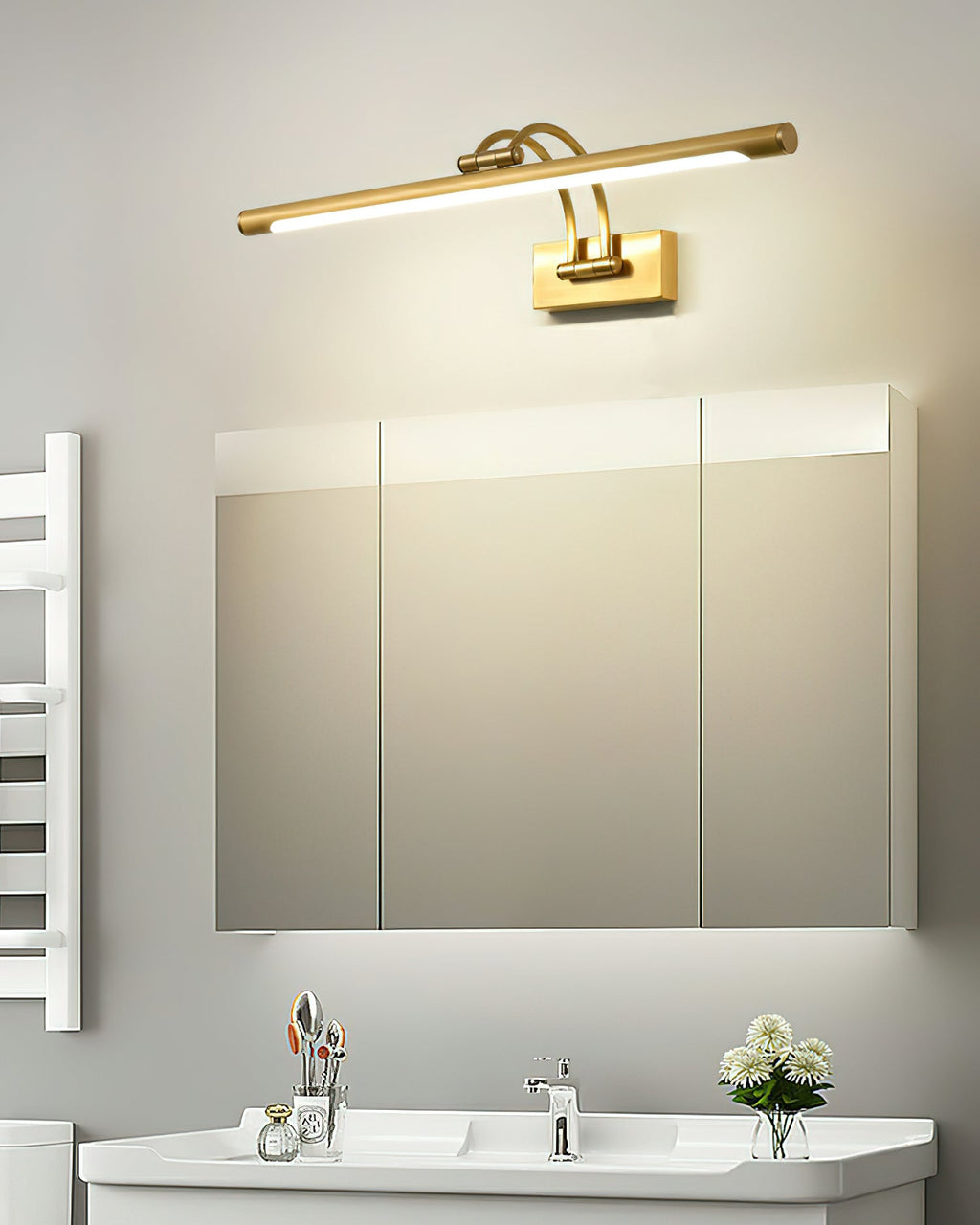 Dark bronze vanity light with brushed brass ends glowing softly