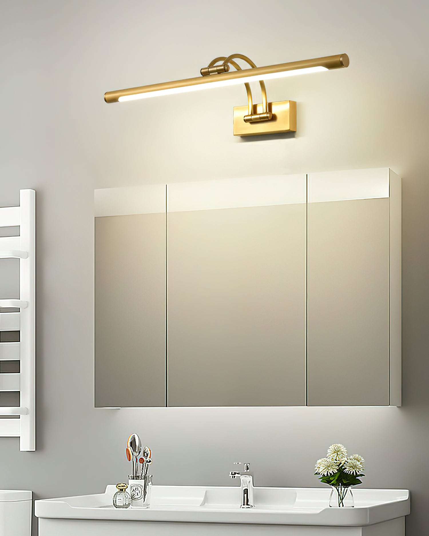 Dark bronze vanity light with brushed brass ends glowing softly
