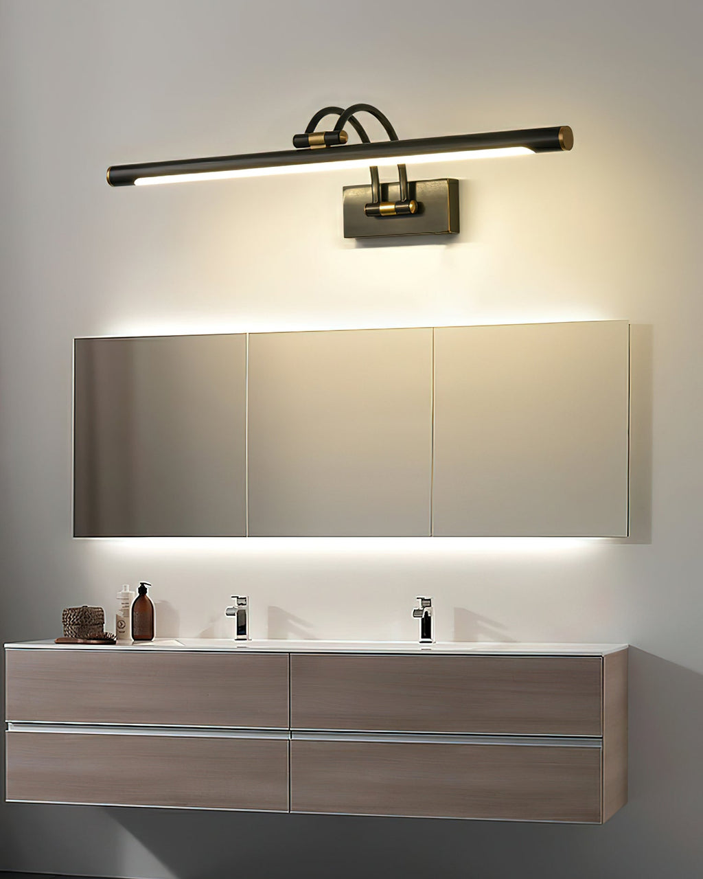 Two-tone vanity wall light glowing warm in a styled bathroom