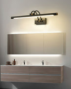 Two-tone vanity wall light glowing warm in a styled bathroom
