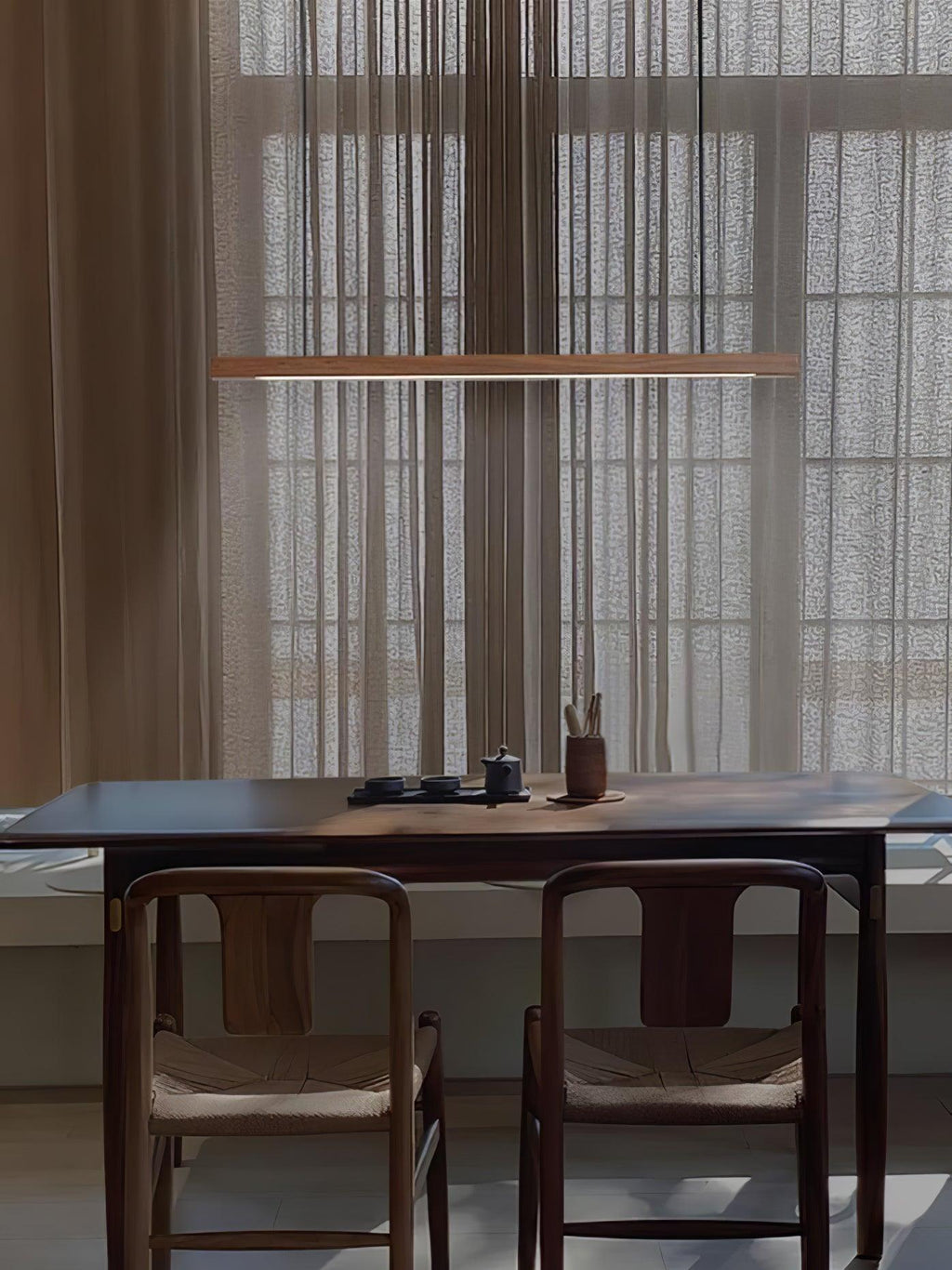 Linear wooden pendant light hanging above a dining table