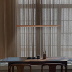 Wooden pendant light slim linear body shown lit warmly