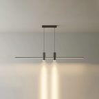 Slim linear bar pendant light suspended above a dining table
