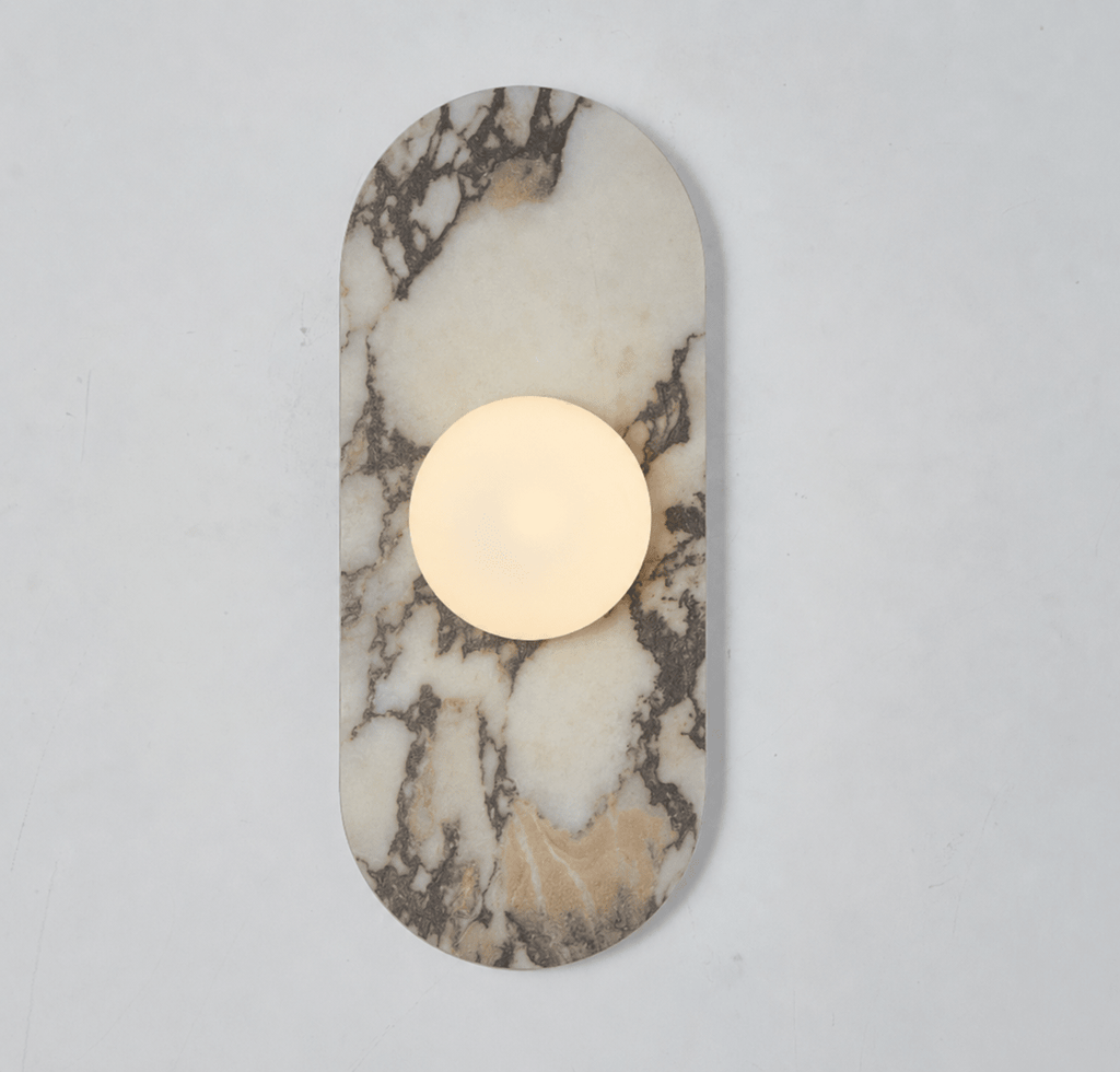 This Clérachic wall sconce's ivory and grey-veined stone capsule glows around a single frosted glass globe on a plain wall.