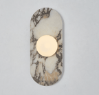 This Clérachic wall sconce's ivory and grey-veined stone capsule glows around a single frosted glass globe on a plain wall.