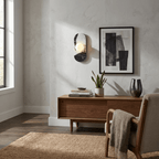 The Clérachic wall sconce lights a living room wall beside a framed print, above a walnut console with a draped throw.