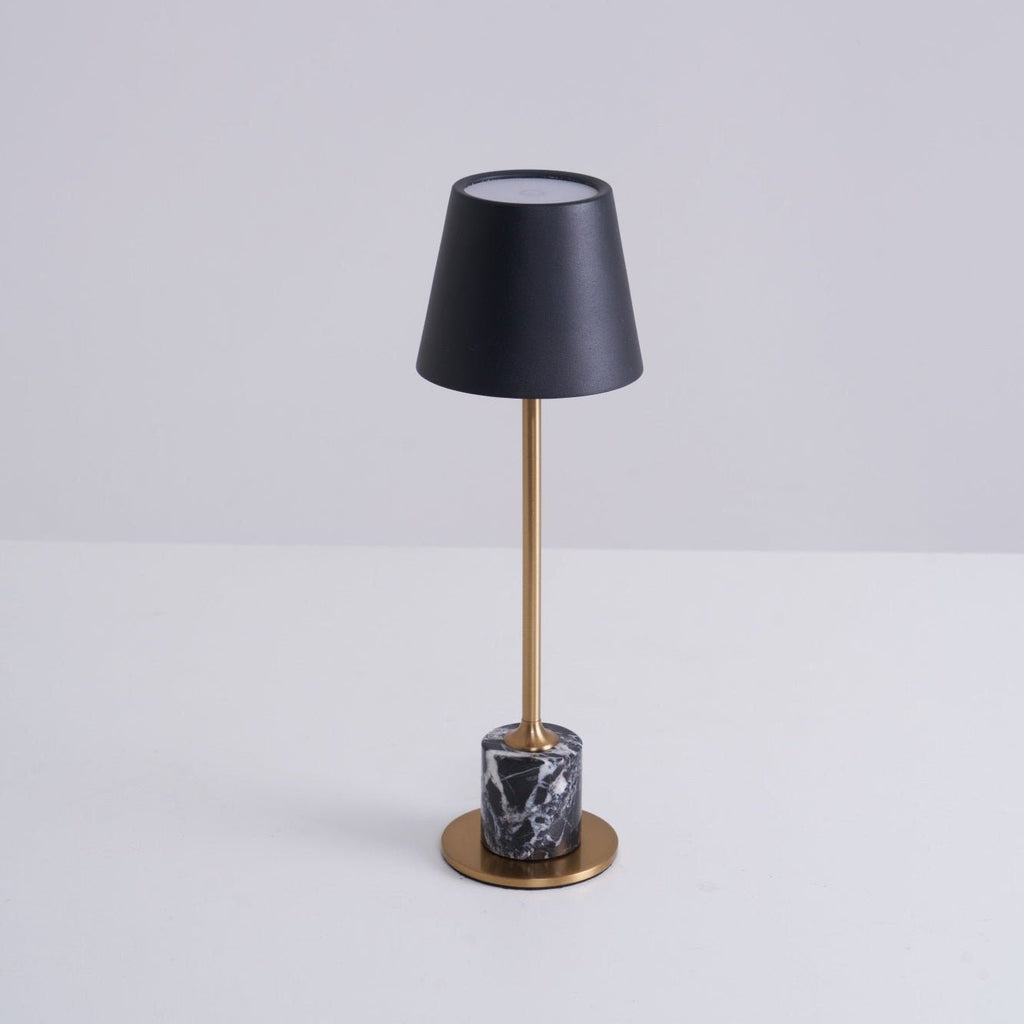 A Clérachic marble table lamp on a plain white studio background, the shade's open top rim visible from this angle.