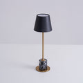 A Clérachic marble table lamp on a plain white studio background, the shade's open top rim visible from this angle.