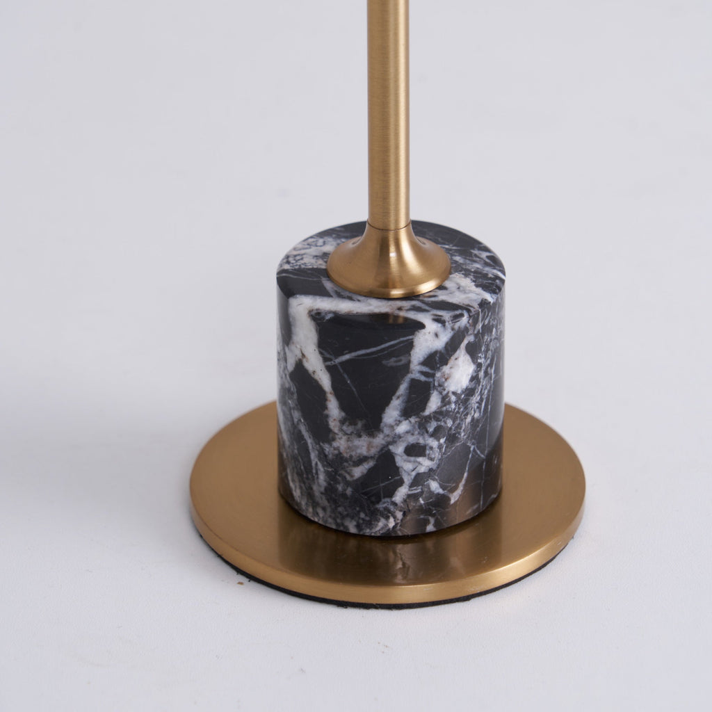 A close-up of the black marbled cylinder base on this Clérachic table lamp reveals the brass rod passing through it to the round foot plate.