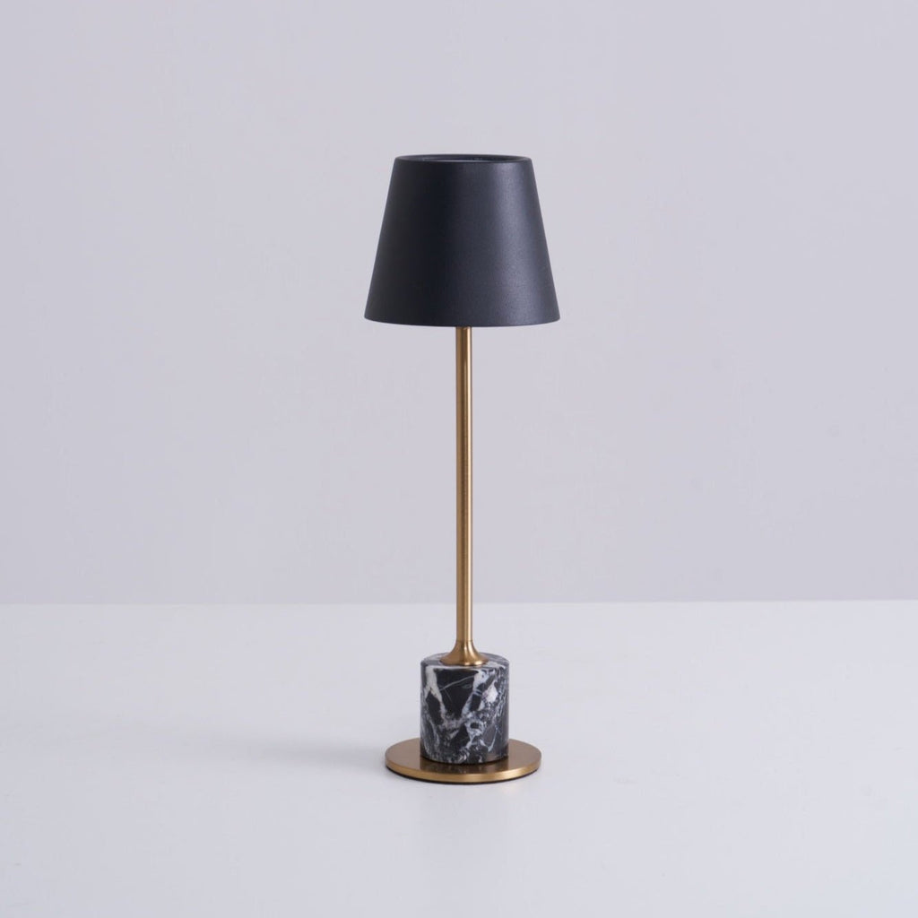 A Clérachic marble table lamp shown in full on a plain white studio background, its shade angled toward the camera.
