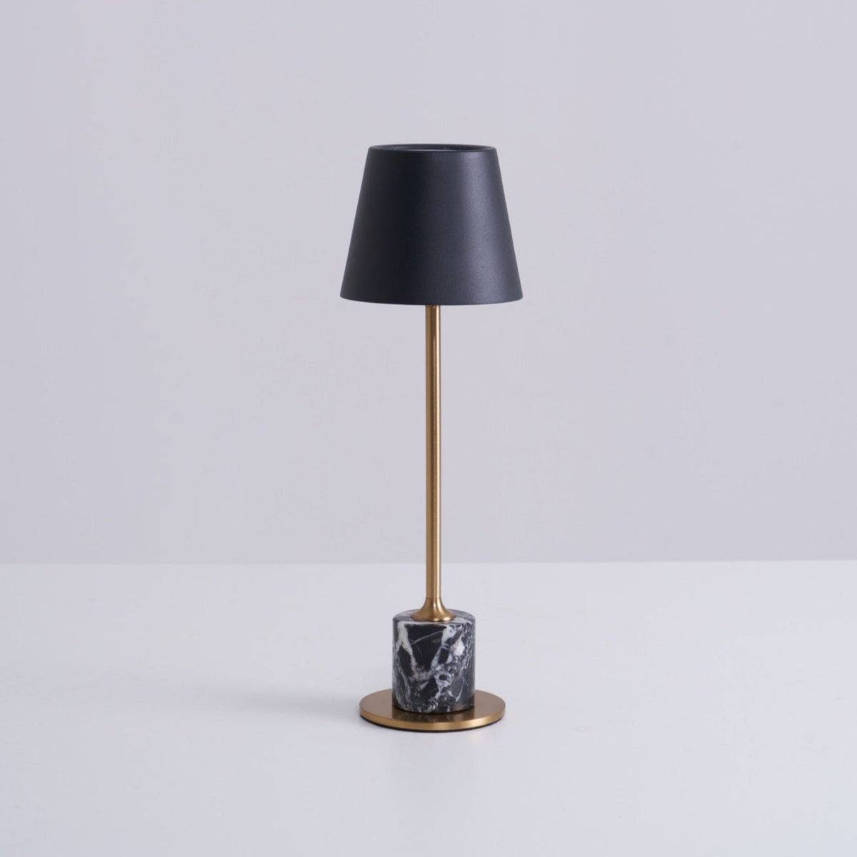 A Clérachic marble table lamp shown in full on a plain white studio background, its shade angled toward the camera.