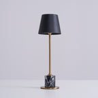 A Clérachic marble table lamp on a plain white studio background, cropped closer to show more of the brass stem.