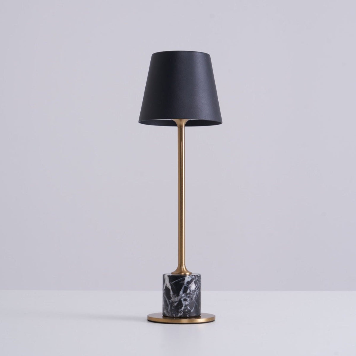 A Clérachic marble table lamp on a plain white studio background, cropped closer to show more of the brass stem.